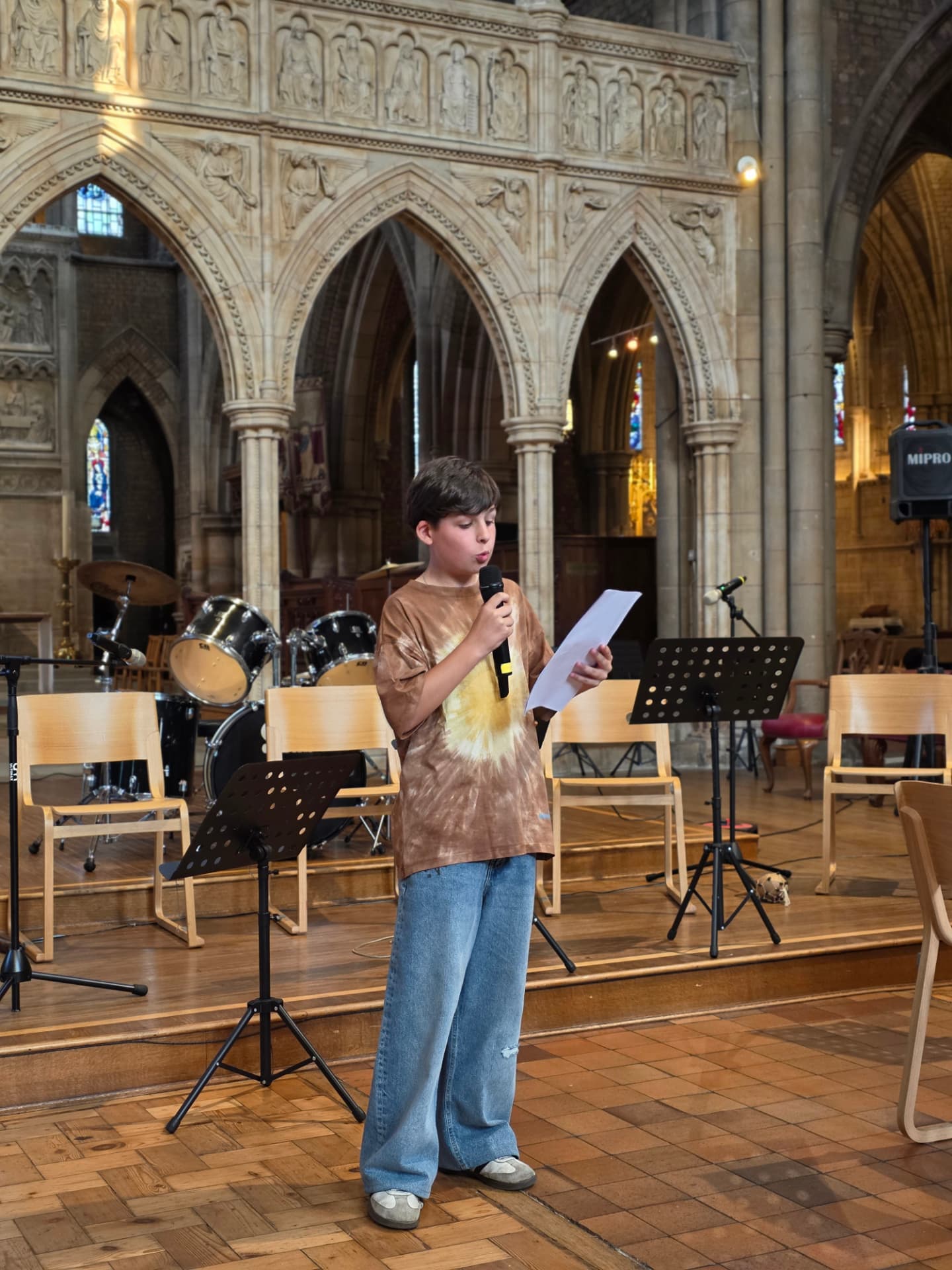 A young student speaking to the audience at the Summer Soirée